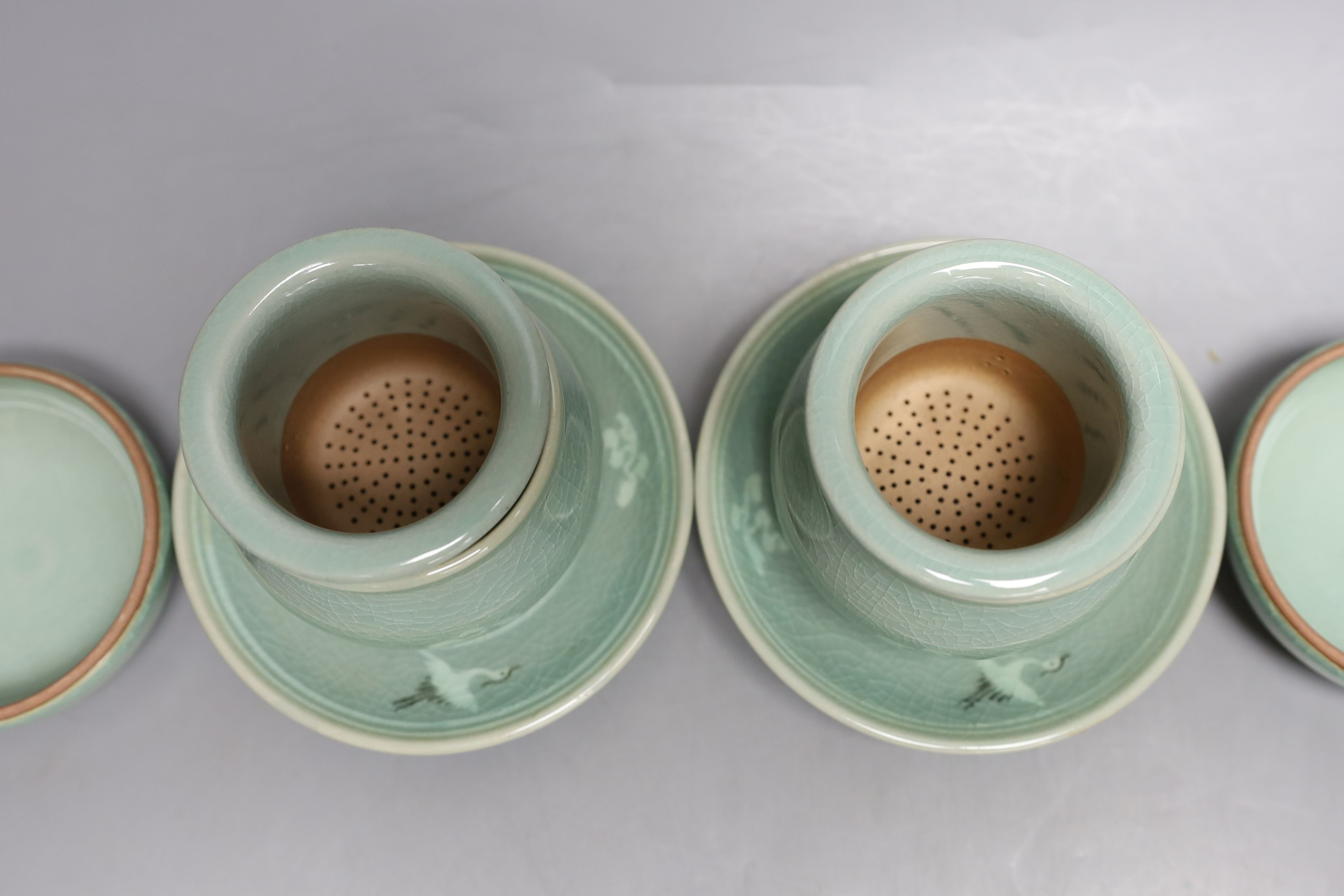 A pair of Korean green glazed pottery tea bowls, cover and stand with strainer each inside - 11cm tall